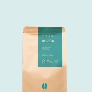 Kaffeepackung aus Packpapier mit blauem Etikett für den Berlin Blend und den Worten Honduras, Ethiopia sowie 100% Arabica, darunter Symbole für Herdkanne, Siebträger und Kaffeefilter. Unter dem Etikett das aufgestempelte Blaue Bohne Rösterei-Logo.